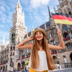 Portrait,Of,A,Young,Female,Tourist,With,German,Flag,Standing