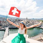 Young,Female,Tourist,With,Swiss,Flag,On,The,Top,Of