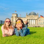Two,Young,Happy,Girls,Wearing,Sun,Glasses,Lying,On,A