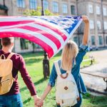 Back,View,Of,Couple,With,American,Flag,Holding,Hands,In
