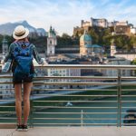Woman,Westerner,Travel,In,Backpack,With,Map,Looking,At,City