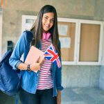 Young,Hispanic,Student,Girl,Smiling,Happy,Holding,Book,And,Uk