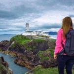 Girl,With,A,Backpack,Looking,At,The,Fanad,Head,Lighthouse