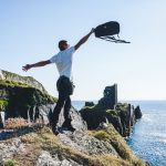 Man,Throws,Up,A,Backpack,On,The,Background,Of,The