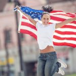 Young,Brunette,Holding,A,Flag,Of,Usa,Jumping,From,Joy