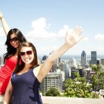Friends,Standing,By,Binoculars,At,Tourist,Area,With,Blue,Sky