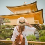 Lady,Tourist,Is,Watching,Kinkaku-ji,Temple,In,Kyoto,,Japan